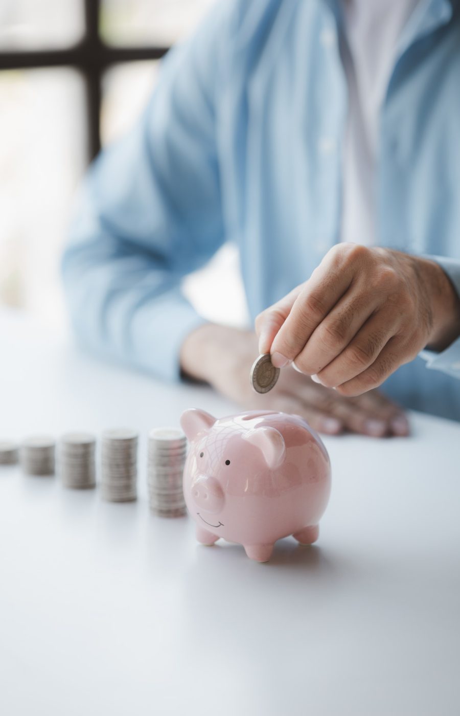 person-with-pile-of-coins-and-piggy-bank-money-saving-concept-for-future-use-and-financial-stabilit.jpg